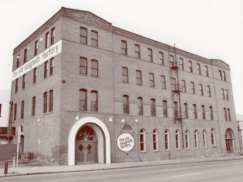 Black-and-white exterior view of the 1890 brick warehouse at 152 S Monroe Street housing The Old Spaghetti Factory in downtown Spokane, Washington