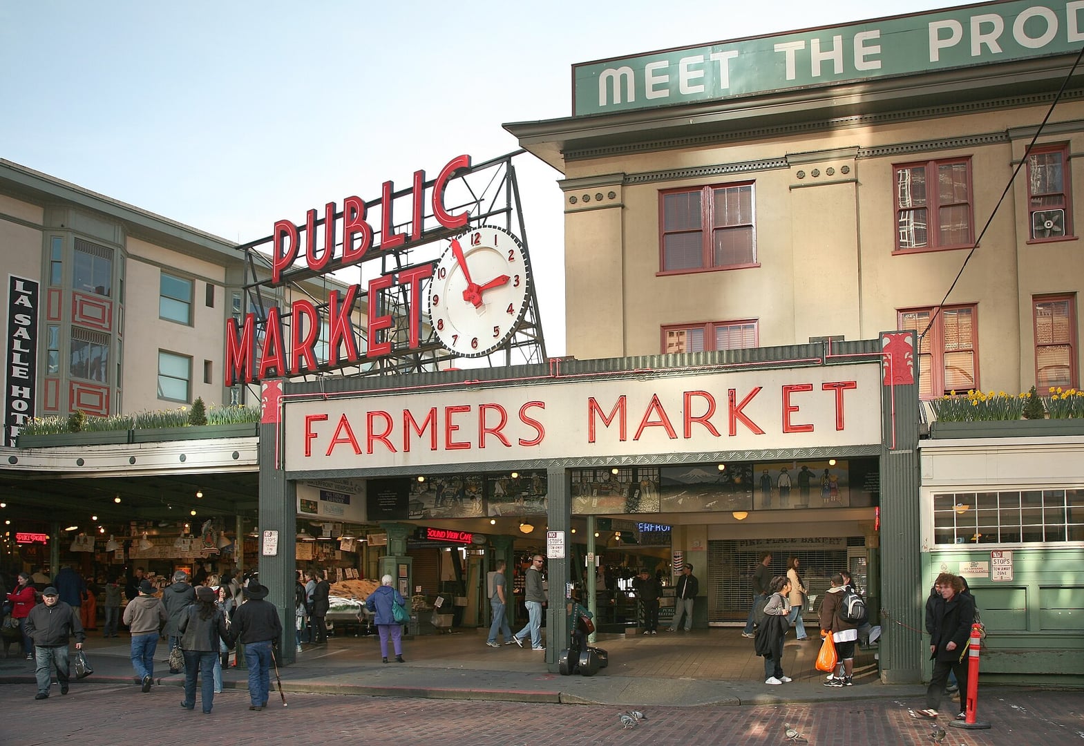 Pike Place Market in Seattle, Washington showing the iconic Public Market Center neon sign and main arcade building fronting First Avenue