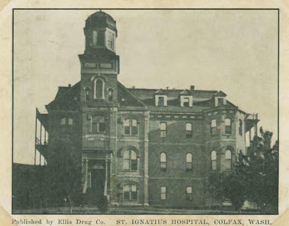 St. Ignatius Hospital in Colfax, Washington, after its 1917 remodel, in a postcard published by Ellis Drug Co. showing the building nearly square-on with its central dome