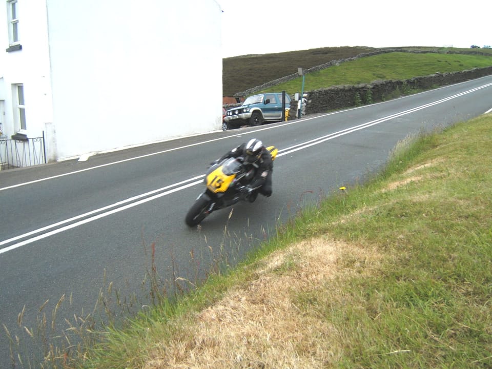 Michael Dunlop at Kate's Cottage in 2009, a left-bend on the TT course starting the run down off the Snaefell Mountain section, riding an updated rotary-engined Norton on a demonstration lap for fans as the bike didn't qualify to race