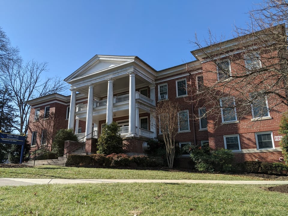 Miller Hall at Shepherd University in Shepherdstown, West Virginia, seen from the lawn in winter, with its two-storey white-columned portico on the red-brick front, January 2020.