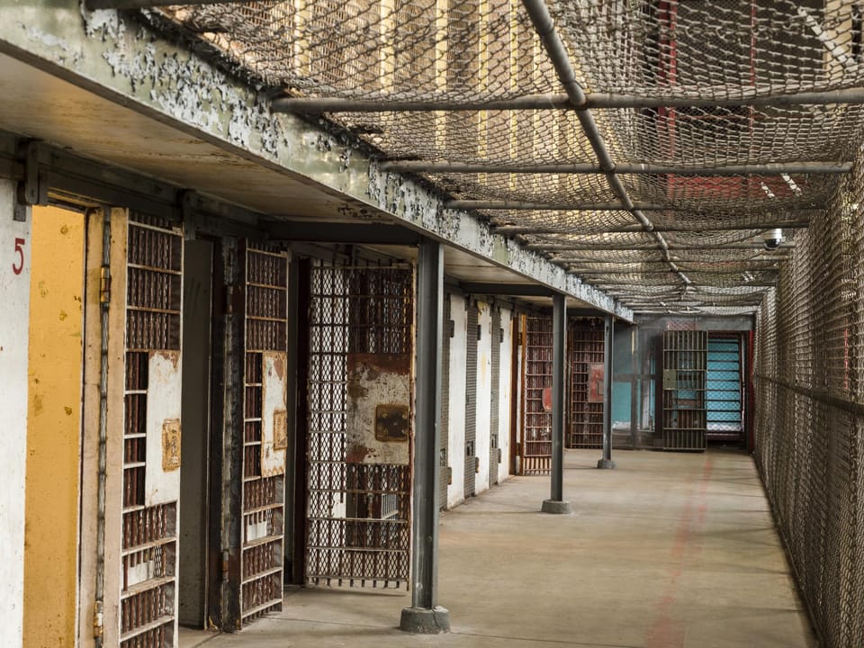 A three-tier cellblock inside the West Virginia State Penitentiary, with anti-suicide wire netting strung above the walkways -- an area shown on the site's public tours.