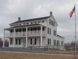 The white Greek Revival façade of the 1843 Dousman Stagecoach Inn at the Elmbrook Historical Society park in Brookfield, Wisconsin