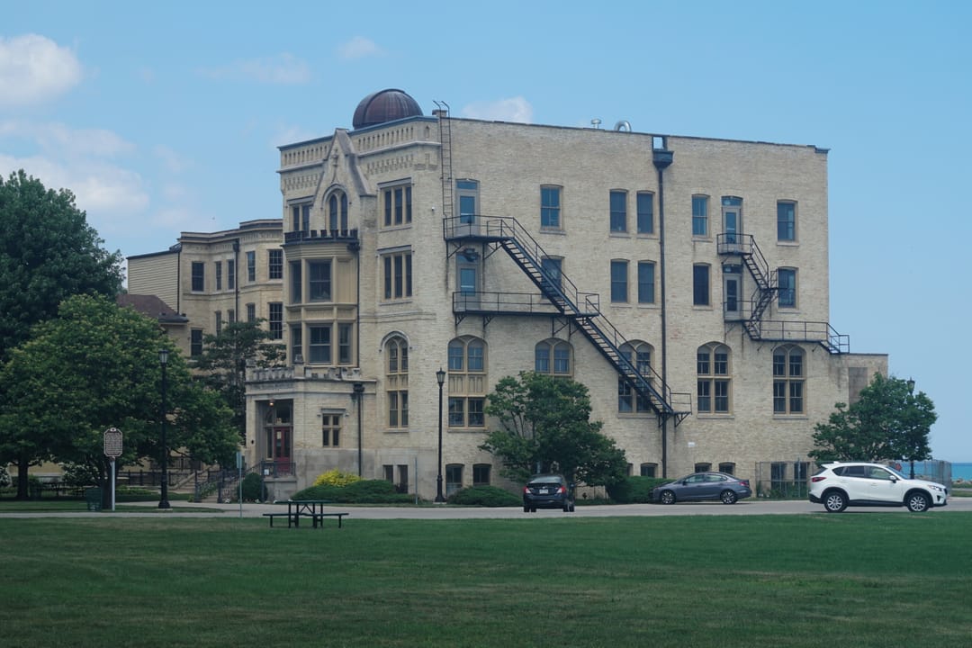 Kemper Hall, Kenosha, Wisconsin, viewed from the lakefront lawn, showing its exterior fire escape and multiple wings.