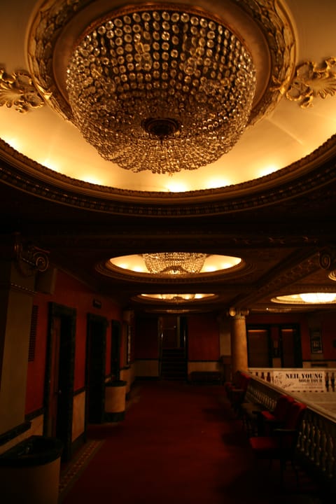 The ornate gilded ceiling dome and crystal chandelier in the Pabst Theater's lobby