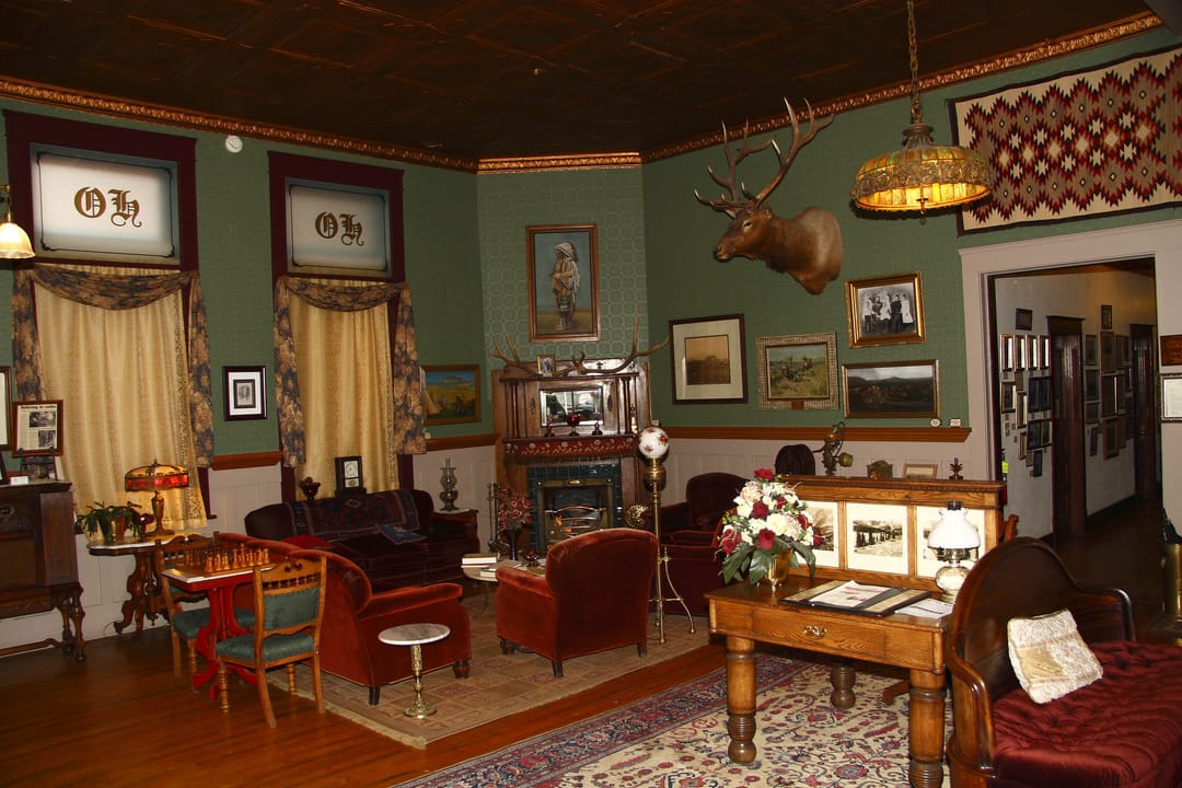 The Occidental Hotel's period-furnished lobby in Buffalo, Wyoming, with monogrammed 'OH' wall panels and a mounted elk head, 2008.
