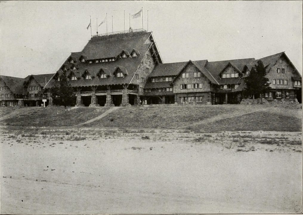 A three-quarter exterior view of the Old Faithful Inn with its signal flags flying, from Reau Campbell's 1916 guidebook to Yellowstone Park.